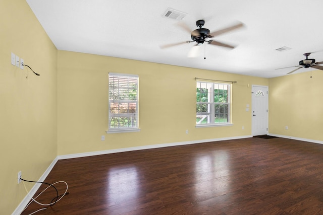 spare room with visible vents, plenty of natural light, and wood finished floors