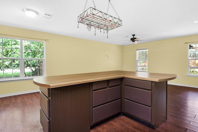 kitchen featuring dark brown cabinetry, dark wood-style flooring, visible vents, baseboards, and light countertops