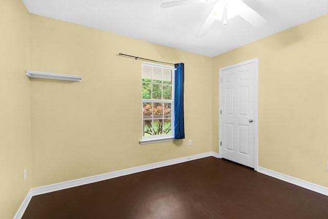 unfurnished room featuring a ceiling fan and baseboards