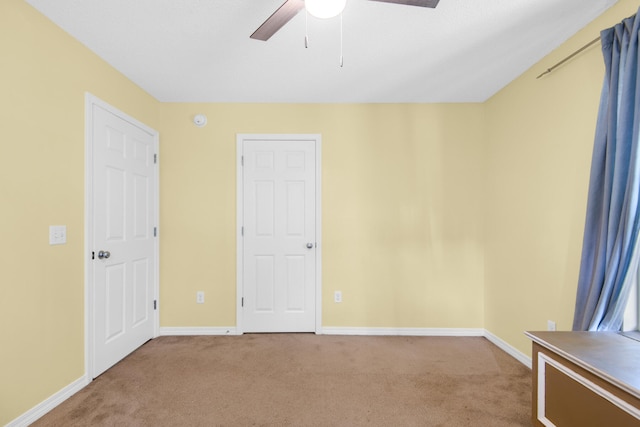 unfurnished bedroom with ceiling fan, carpet, and baseboards