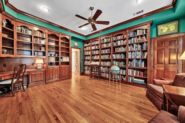 office space featuring ceiling fan, light wood-type flooring, built in features, and ornamental molding