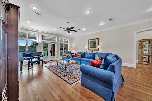 living room featuring french doors, ceiling fan, light hardwood / wood-style floors, and crown molding