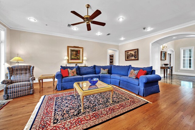 living room featuring ornamental molding, ceiling fan, and light wood-type flooring