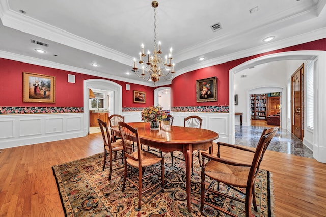 dining area featuring light hardwood / wood-style floors, an inviting chandelier, and ornamental molding