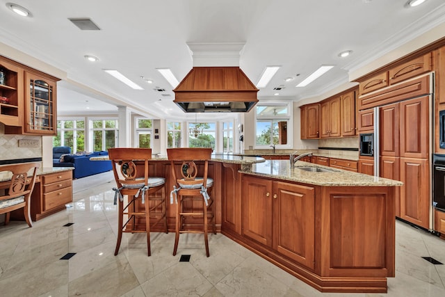 kitchen with tasteful backsplash, a kitchen island with sink, and light tile floors