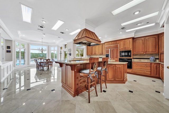 kitchen featuring a center island, an inviting chandelier, black appliances, and light tile floors