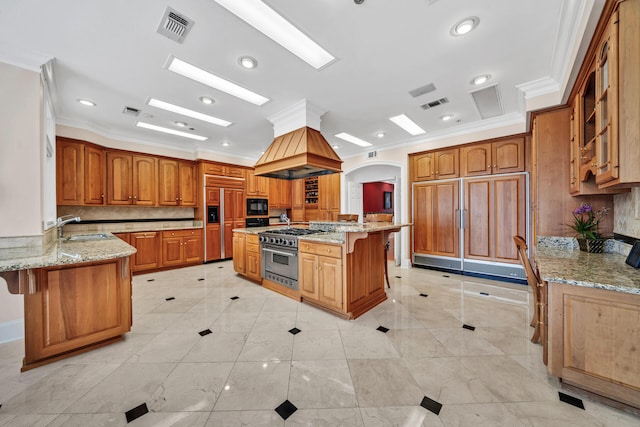 kitchen featuring a center island with sink, light stone countertops, light tile flooring, and black appliances