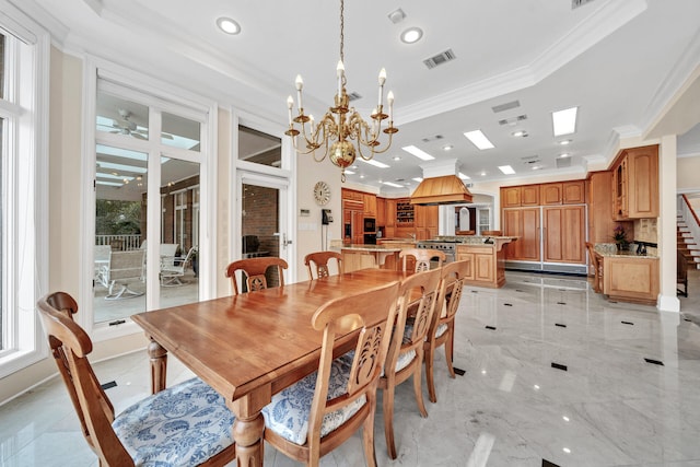 dining room featuring ceiling fan with notable chandelier, a tray ceiling, crown molding, and light tile floors