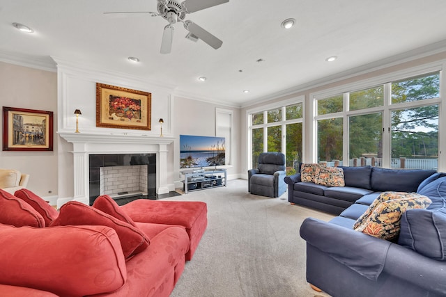 living room with ornamental molding, a wealth of natural light, a tile fireplace, and light carpet