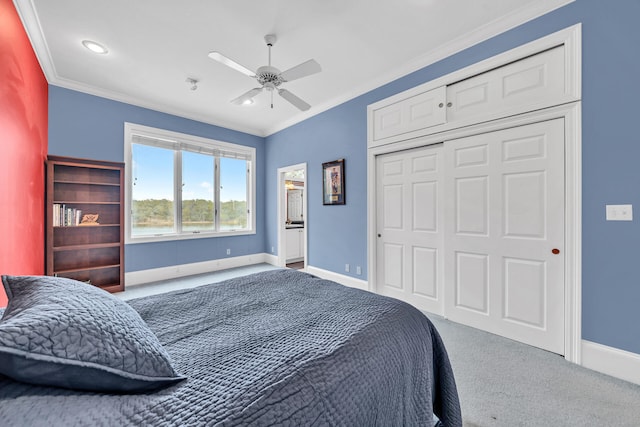 bedroom featuring light carpet, a closet, ceiling fan, and crown molding