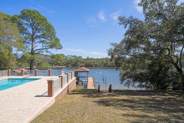 view of dock with a fenced in pool, a patio area, a water view, and a lawn