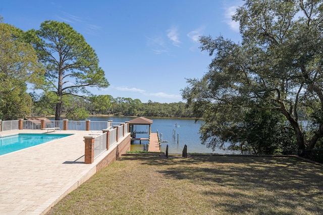 dock area featuring a fenced in pool, a patio, a yard, and a water view