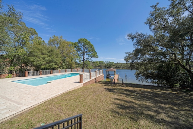 view of pool featuring a patio, a yard, and a water view