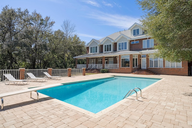 view of pool featuring a patio area and a diving board