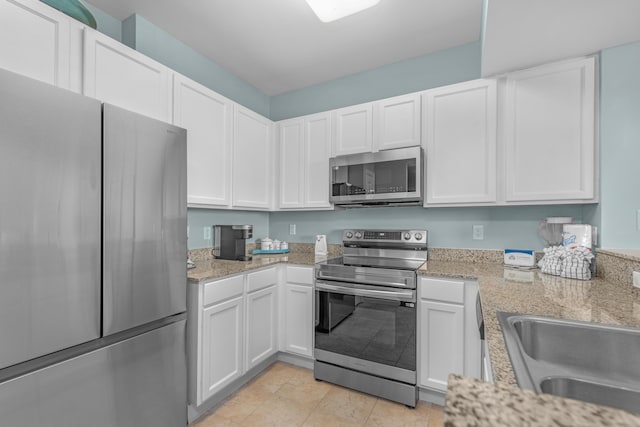 4203 Indian Bayou Trl Unit 1712, Destin, FL 32541 - kitchen with stainless steel appliances, a sink, white cabinets, and light stone countertops