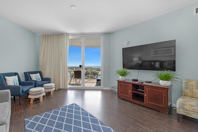 living room featuring dark wood-type flooring and floor to ceiling windows