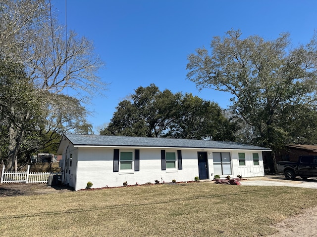 ranch-style home featuring central AC unit and a front yard