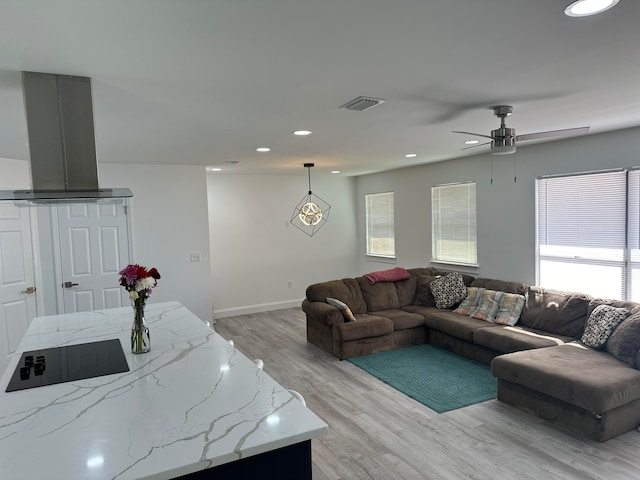 living room featuring a wealth of natural light, ceiling fan, and light hardwood / wood-style floors