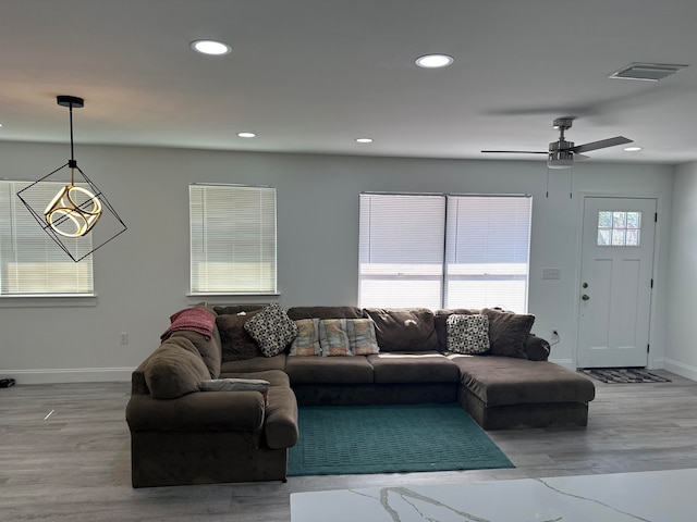 living room featuring wood-type flooring and ceiling fan