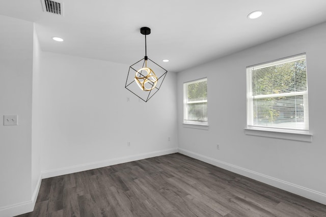 unfurnished room with dark wood-type flooring and an inviting chandelier