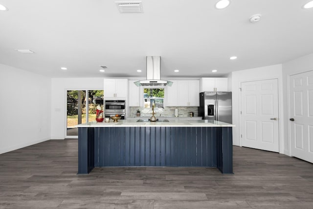 kitchen featuring decorative backsplash, stainless steel appliances, island range hood, a spacious island, and white cabinets