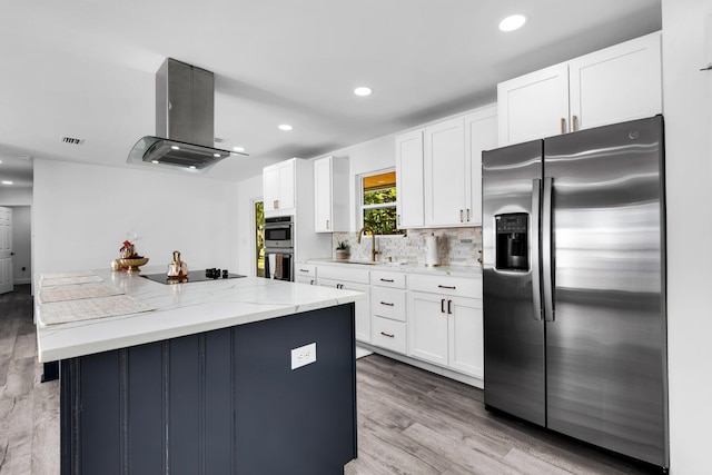 kitchen featuring white cabinets, island range hood, light stone counters, and stainless steel appliances