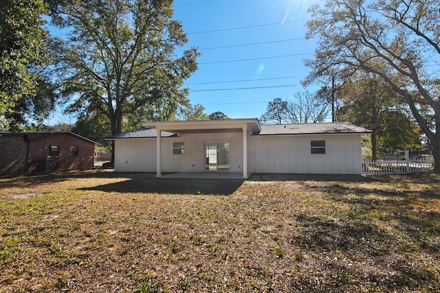 back of property with a patio area and a yard