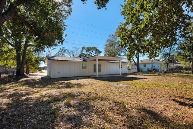 rear view of property featuring a patio area and a lawn