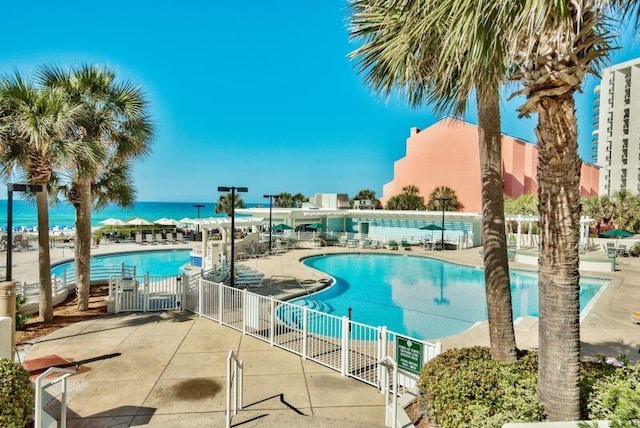 view of swimming pool with a water view and a patio area