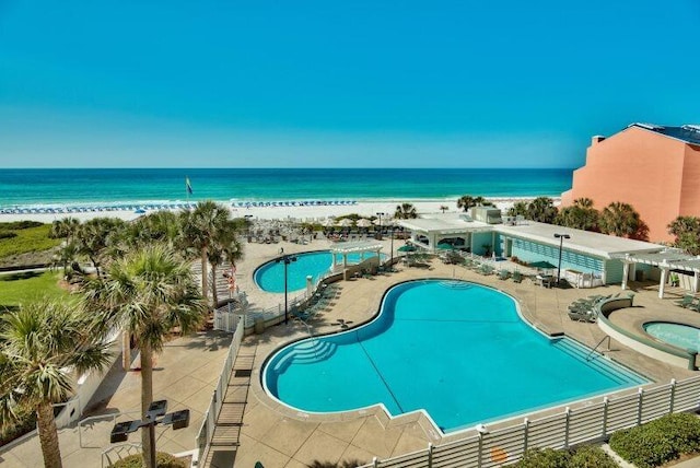 view of pool featuring a view of the beach and a water view