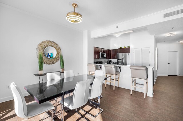 dining area featuring ornamental molding and dark wood-type flooring