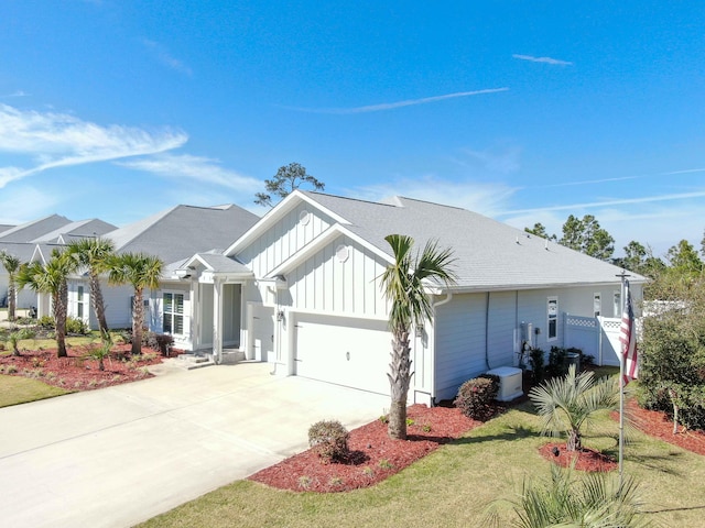 view of front of property with a front yard, a garage, and central AC