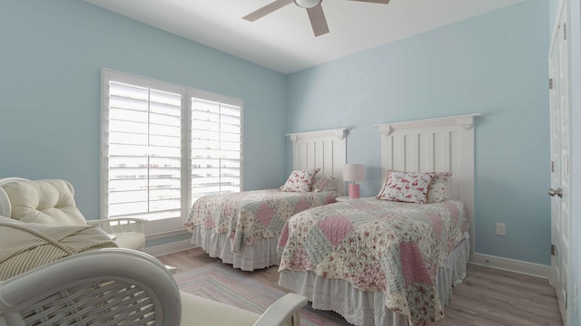 bedroom with light wood-type flooring, multiple windows, and ceiling fan