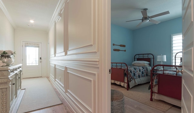 bedroom featuring crown molding, light hardwood / wood-style floors, and ceiling fan