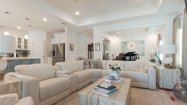 carpeted living room with a tray ceiling, an inviting chandelier, and ornamental molding