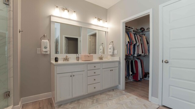 bathroom with dual sinks, wood-type flooring, and oversized vanity