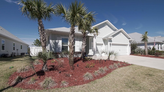 view of front of property featuring a garage, central air condition unit, and a front lawn