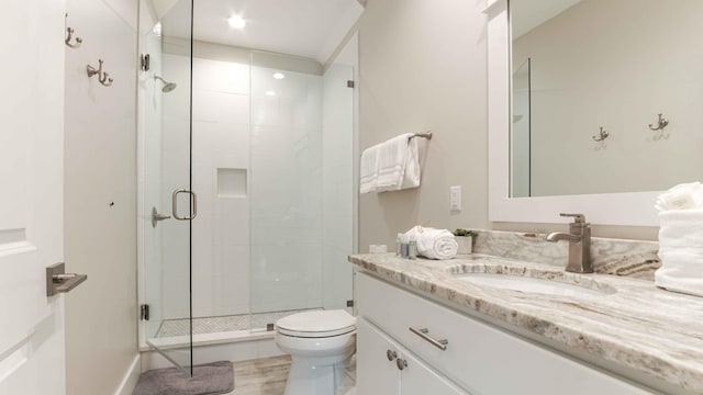 bathroom with a shower with shower door, toilet, and large vanity