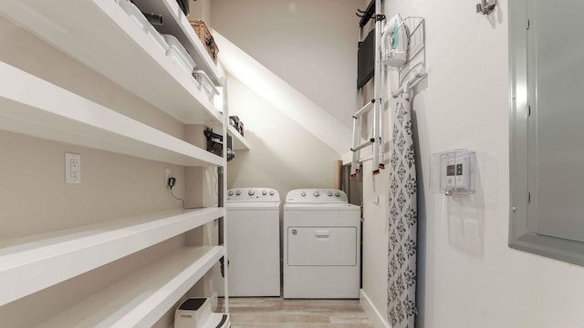 laundry area with light hardwood / wood-style floors and washing machine and dryer