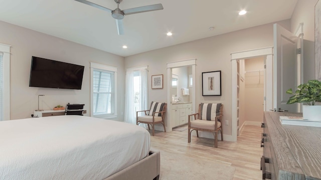 bedroom featuring ceiling fan, a closet, a walk in closet, light wood-type flooring, and connected bathroom