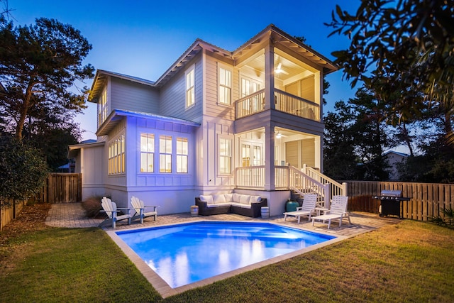 rear view of house with a patio, a lawn, a balcony, and an outdoor living space