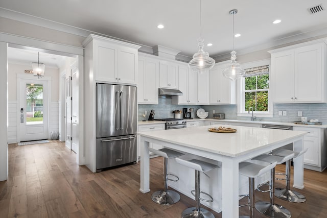 kitchen featuring backsplash, dark hardwood / wood-style floors, pendant lighting, and high end appliances