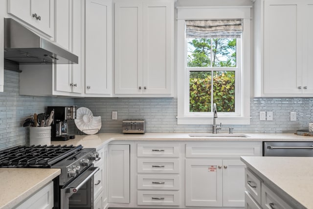 kitchen with backsplash, appliances with stainless steel finishes, and white cabinets