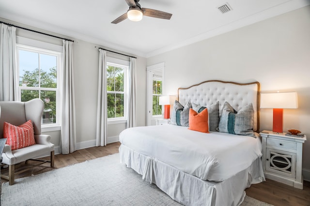 bedroom featuring crown molding, ceiling fan, light hardwood / wood-style floors, and multiple windows