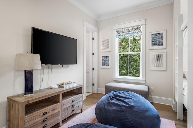 bedroom featuring ornamental molding and light wood-type flooring