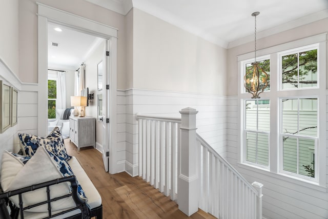 hallway with plenty of natural light, light wood-type flooring, and ornamental molding