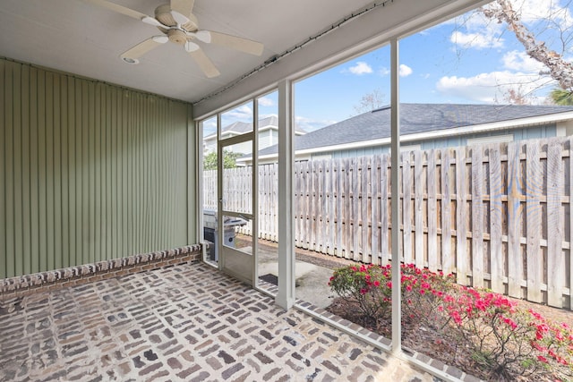 unfurnished sunroom featuring ceiling fan