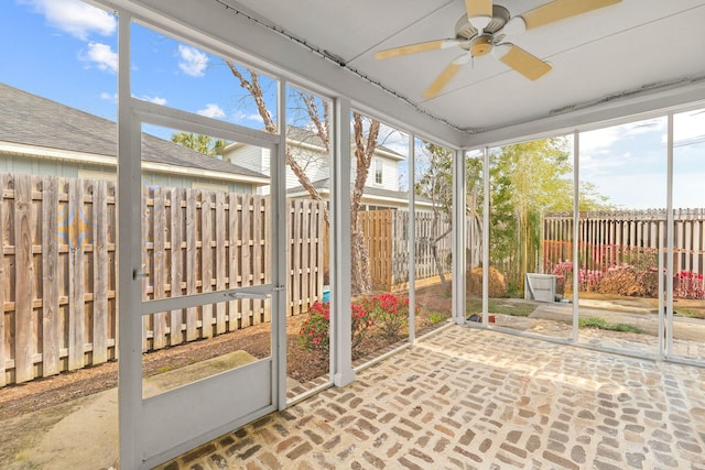 unfurnished sunroom with ceiling fan