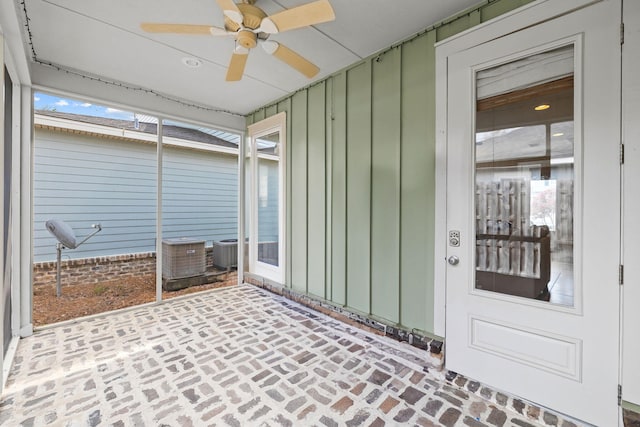 unfurnished sunroom featuring a healthy amount of sunlight and ceiling fan