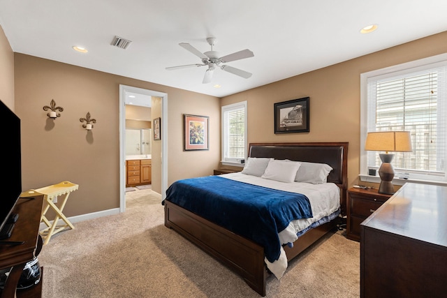 carpeted bedroom with ceiling fan and ensuite bathroom